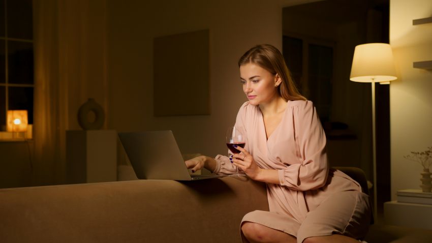 Vrouw zit op de Bank met haar Laptop, Online Daten